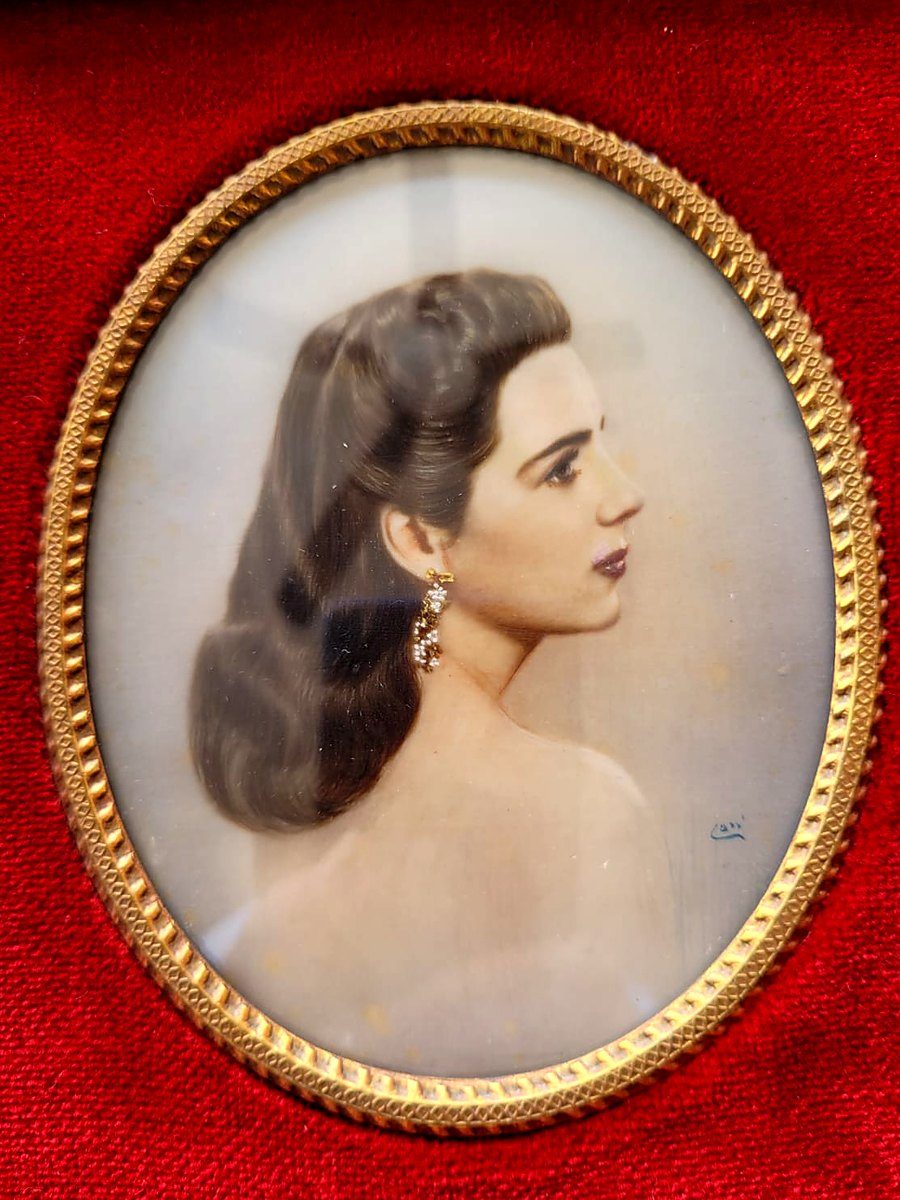 Retrato a color de una mujer joven, de perfil, en un marco ovalado dorado