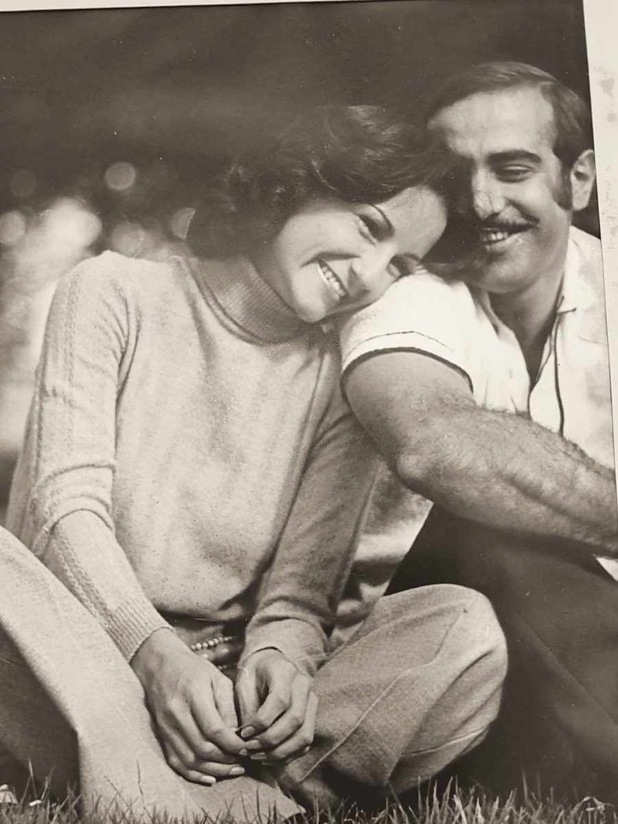 Una pareja sonriente, sentada en el pasto