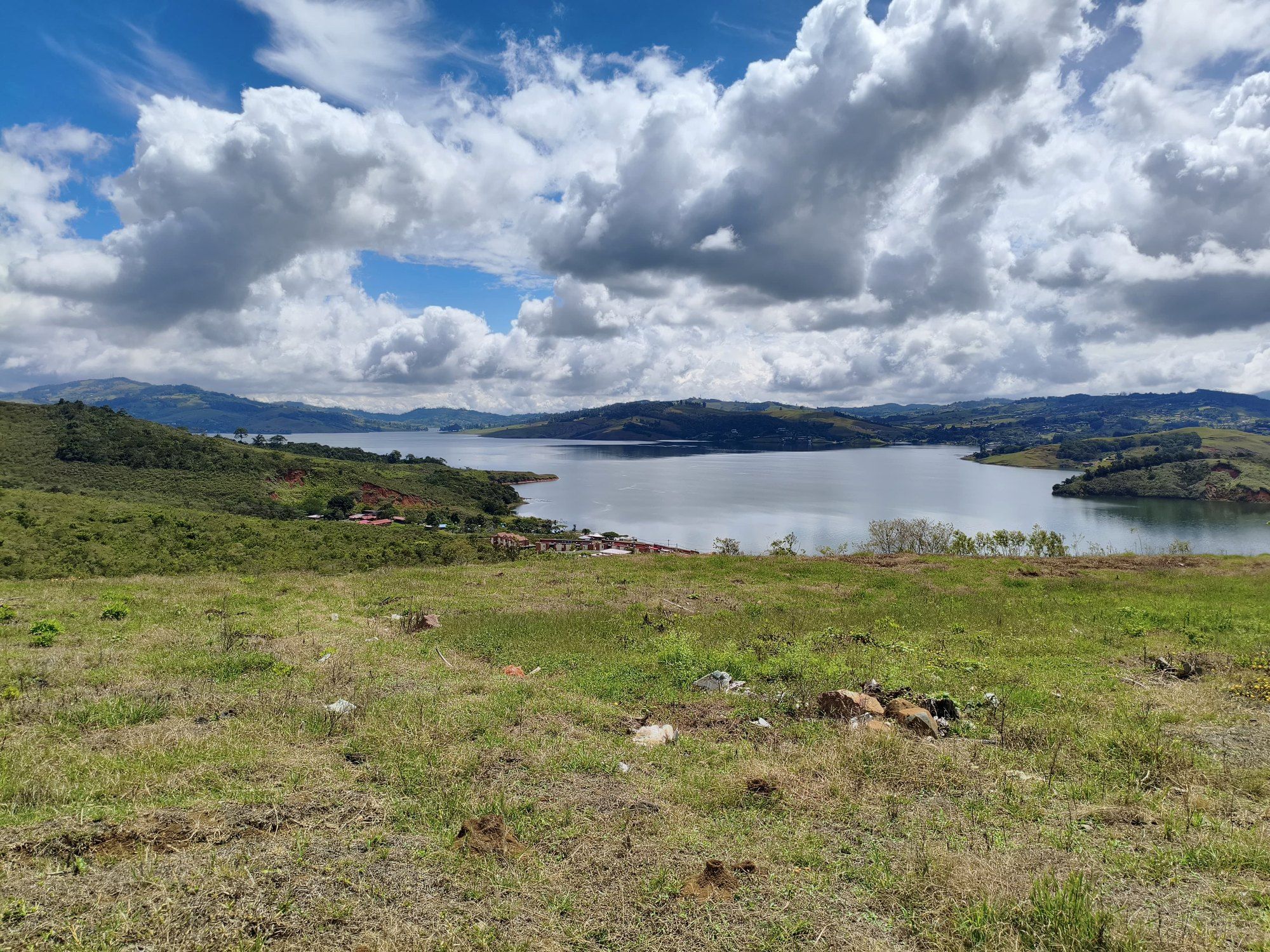 The estate's pasture with the lake and big clouds beyond