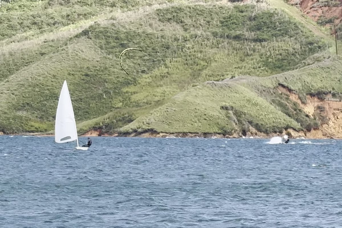 Un velero de una persona bajo las lomas de la orilla, 2026.
