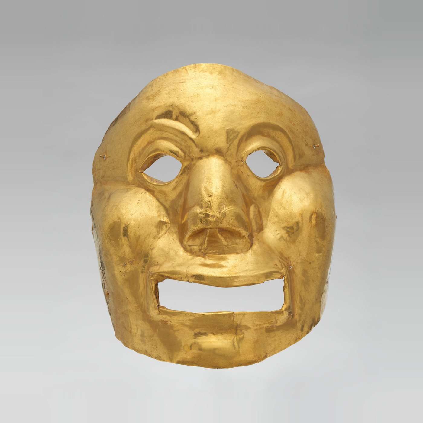 Máscara de oro martillado del período Ilama, con ojos y boca abiertos
