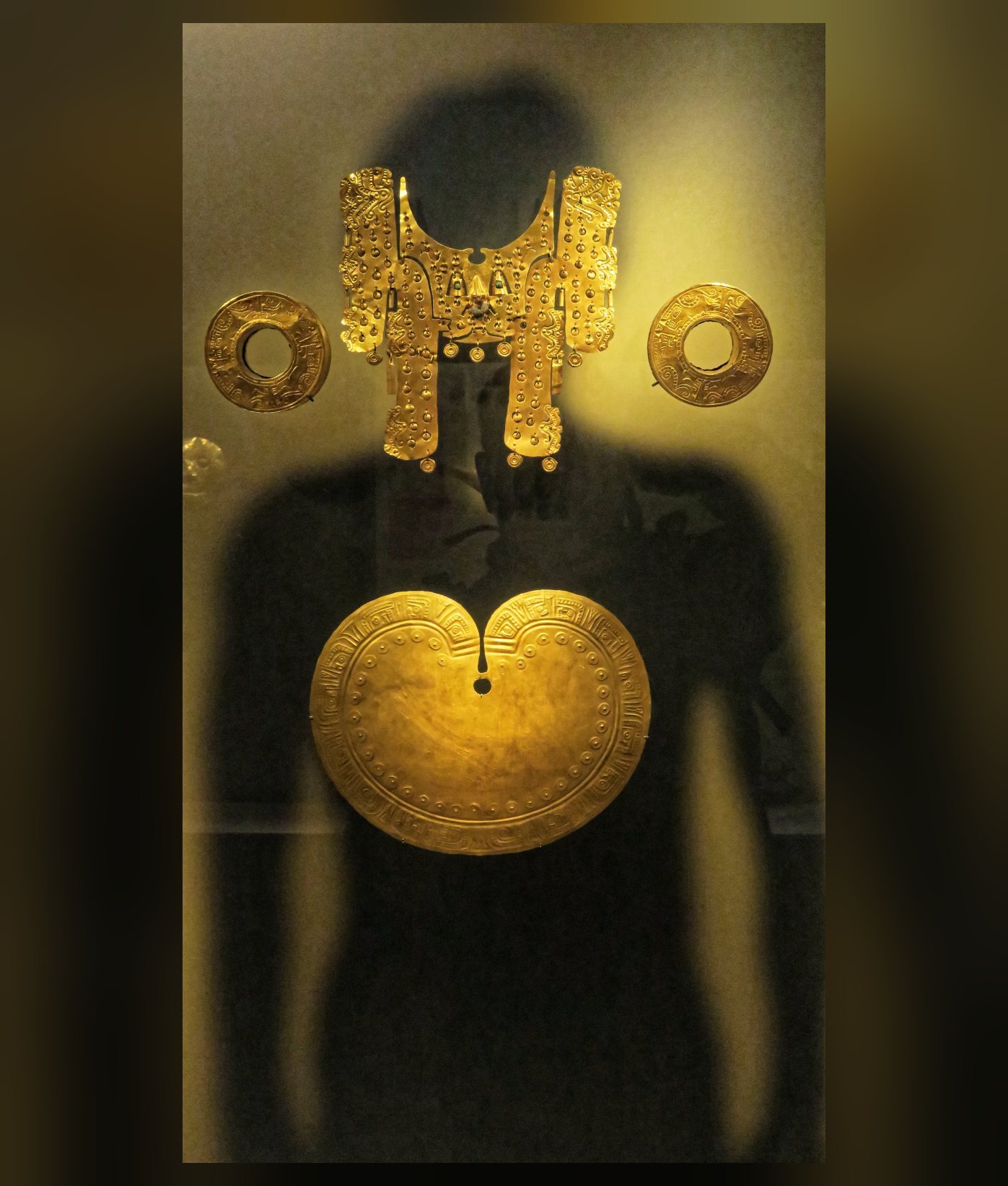 Ajuar de oro de una tumba Yotoco montado sobre una silueta: tocado, orejeras, nariguera y pectoral