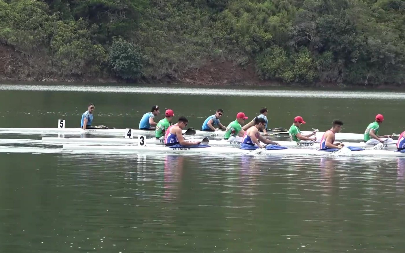 Botes K-4 alineados en la salida de una regata de canotaje en el lago