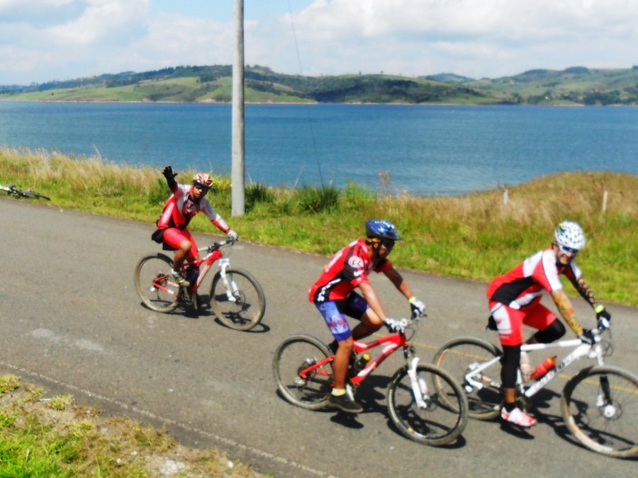 Ciclistas de montaña en la carretera junto al lago